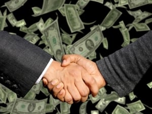 Handshake with money at the background. 