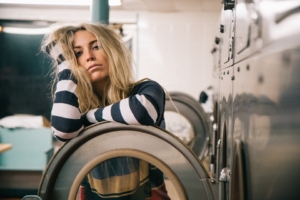 Female standing next to the laundry machine.